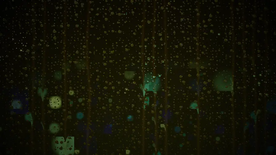 Rain running down dark glass with colored lights blurred behind it